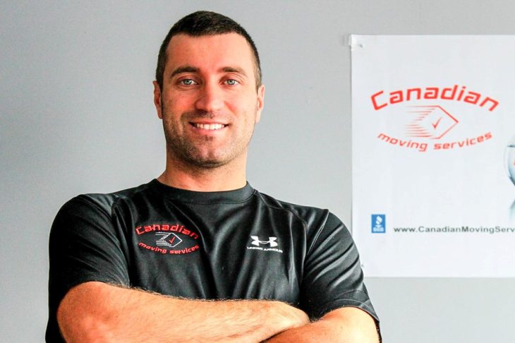 A man with the board of Canadian Moving Service