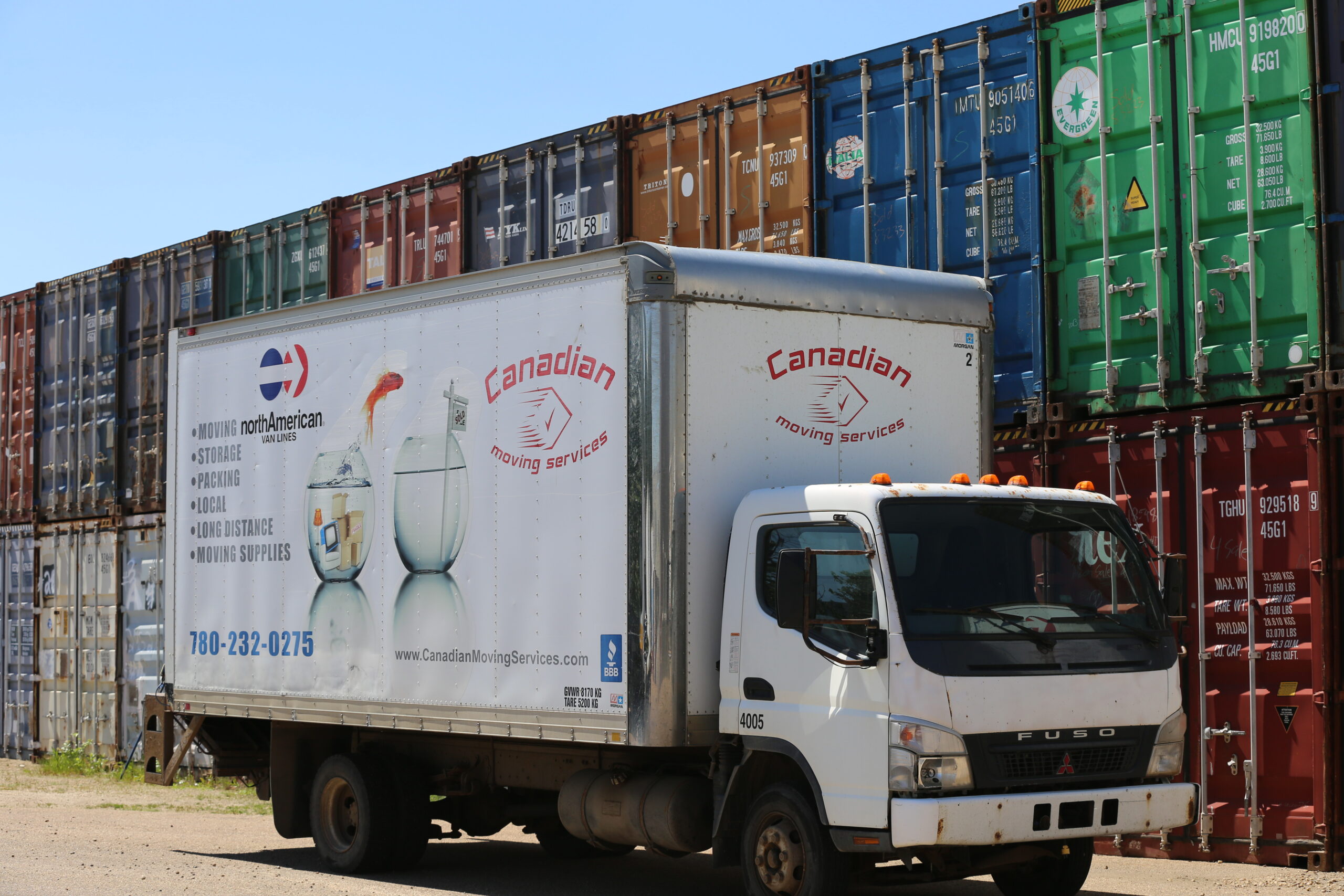 A close shot of Canadian Moving Services Truck stand with sea can