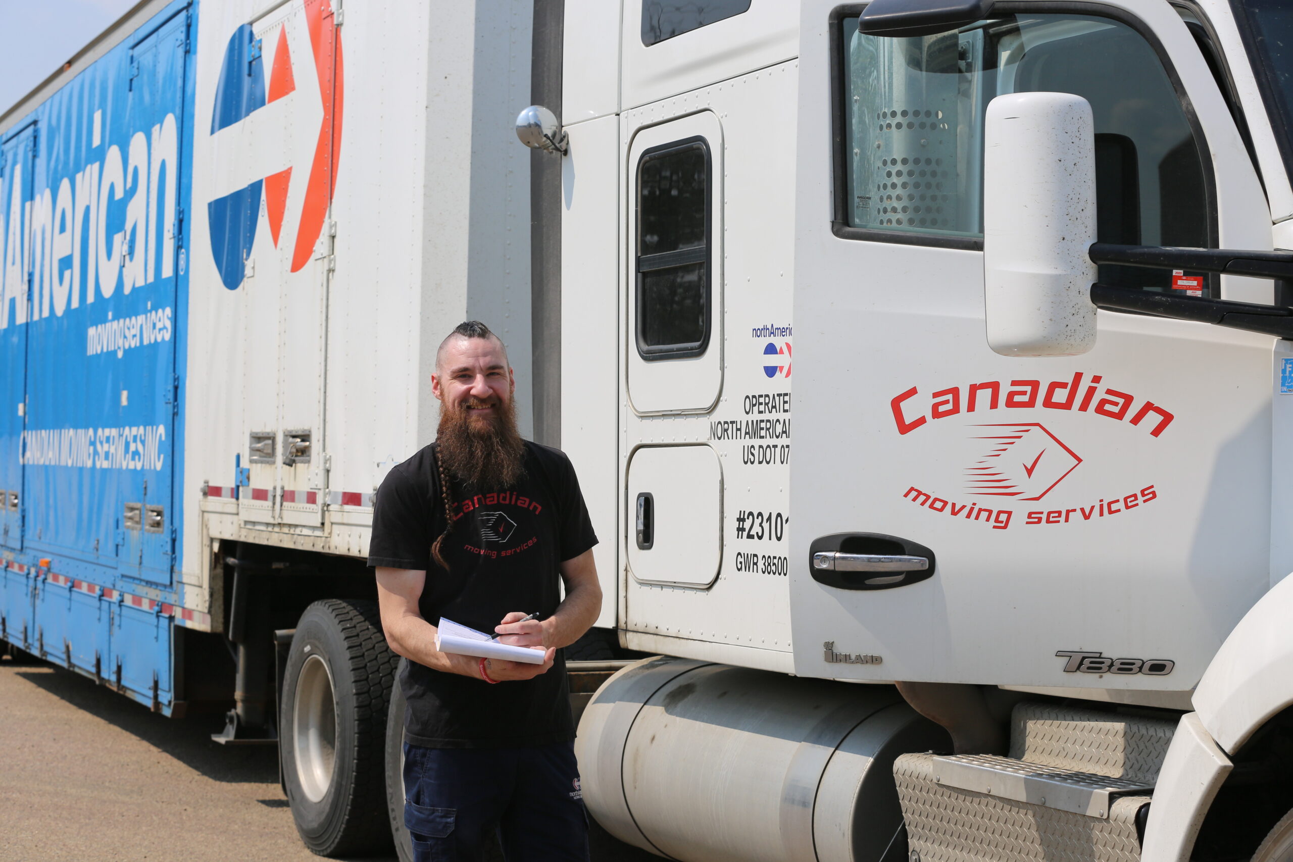 A man stands with Canadian Moving Services Truck